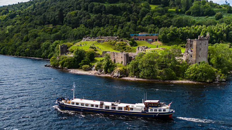 Scottish Highlander cruising past Urquhart castle